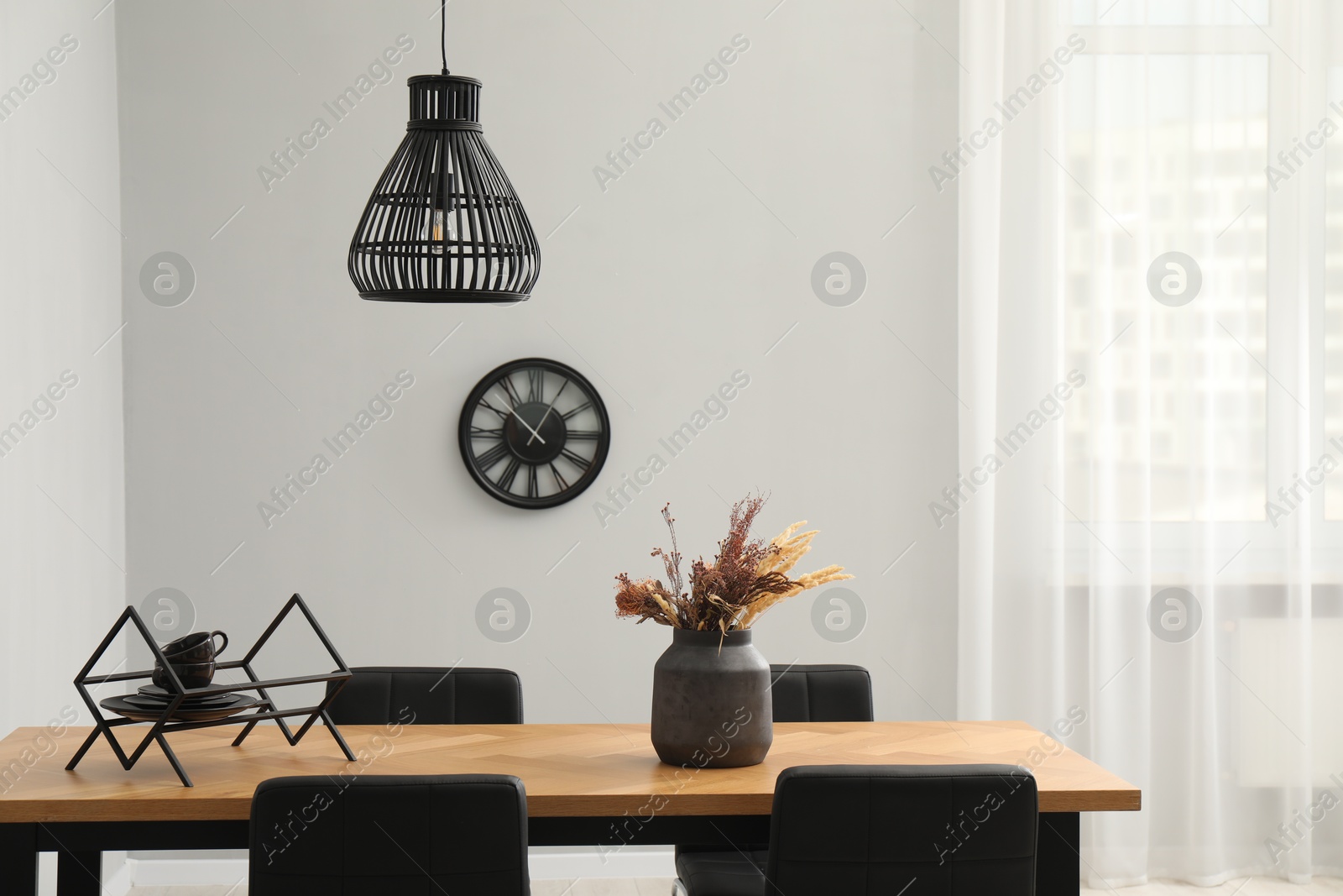 Photo of Wooden table with black chairs in stylish dining room