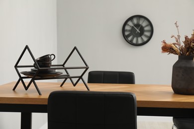 Photo of Wooden table with black chairs in stylish dining room