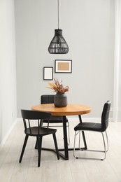 Photo of Wooden table with black chairs in stylish dining room