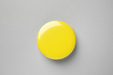 Photo of Blank yellow button badge on grey background, top view. Mockup for design