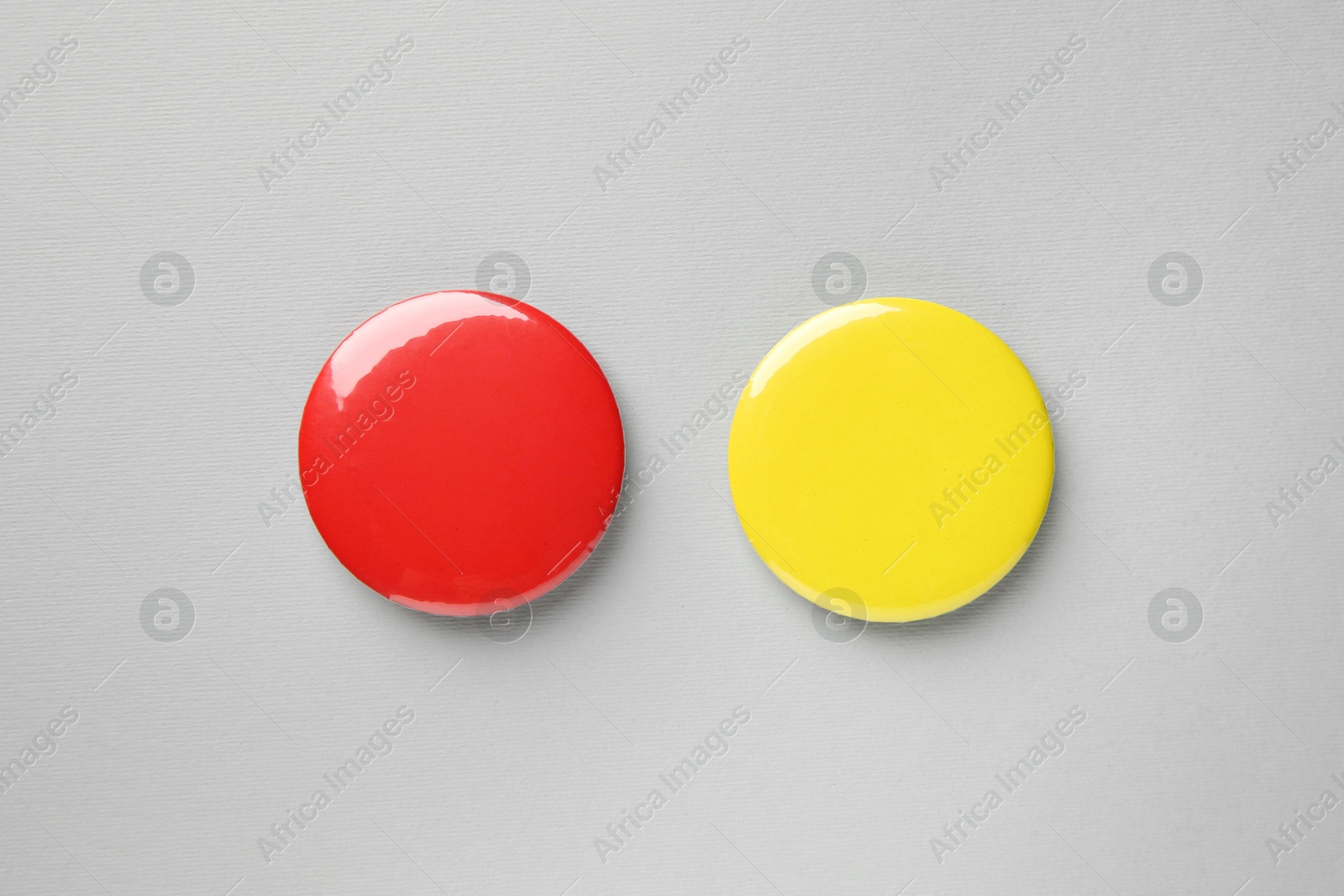 Photo of Blank colorful button badges on grey background, top view. Mockup for design