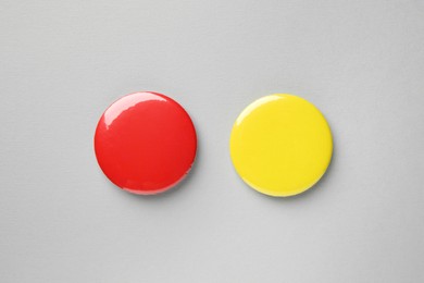 Photo of Blank colorful button badges on grey background, top view. Mockup for design