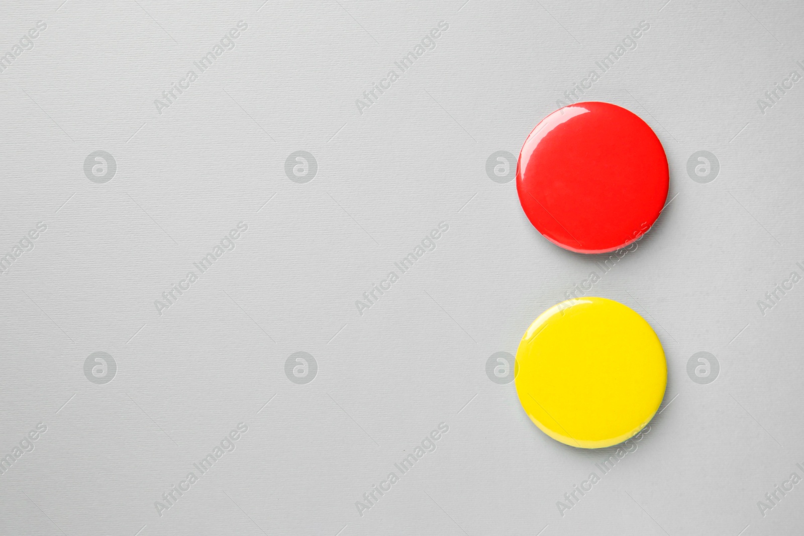 Photo of Blank colorful button badges on grey background, top view and space for text. Mockup for design