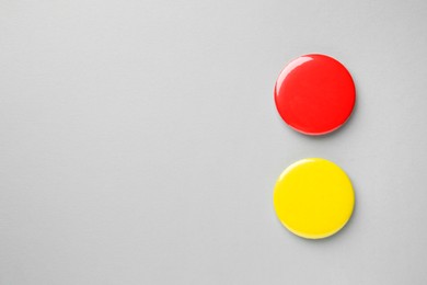 Blank colorful button badges on grey background, top view and space for text. Mockup for design