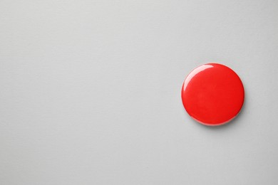 Blank red button badge on grey background, top view and space for text. Mockup for design