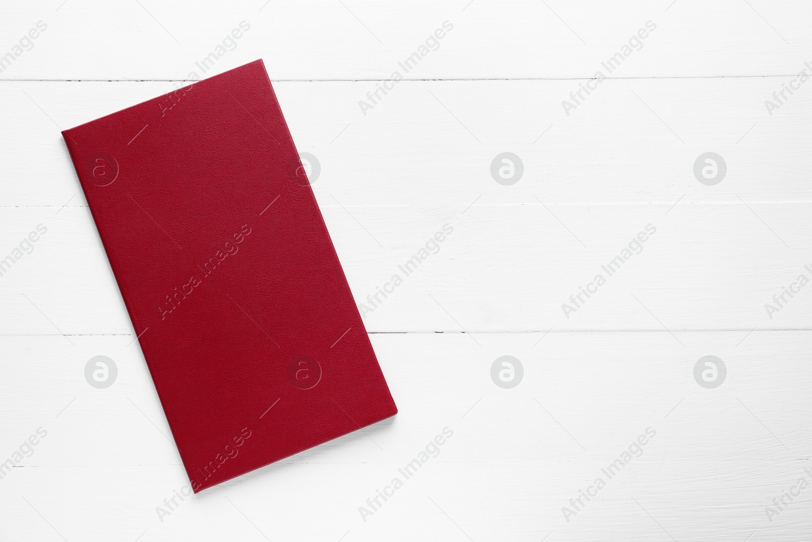 Photo of Hardcover book on white wooden table, top view. Space for text