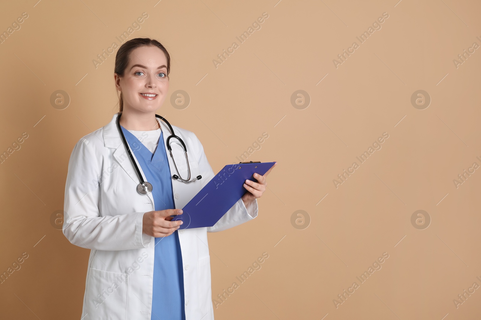 Photo of Portrait of professional nurse with clipboard on dark beige background. Space for text