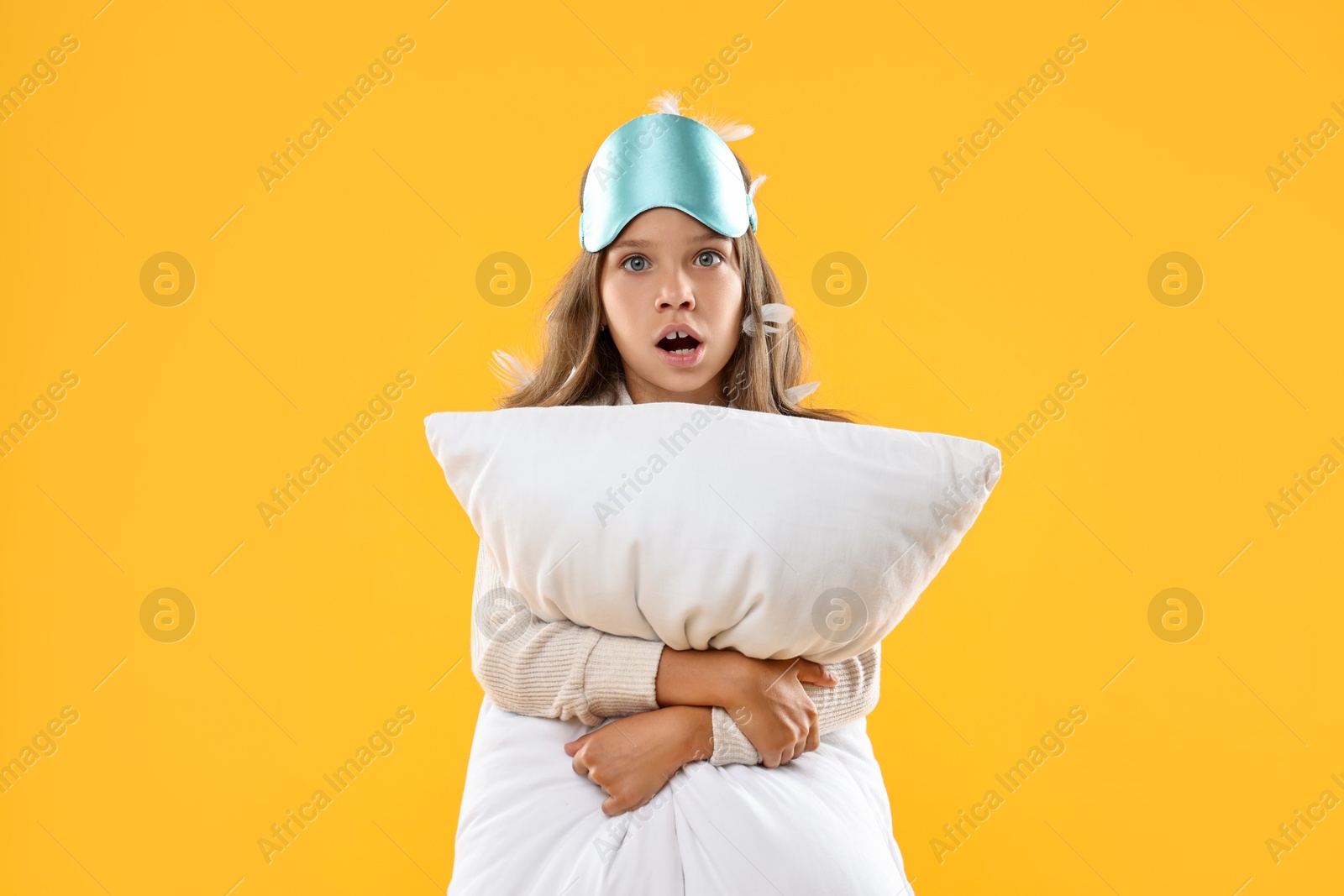 Photo of Overslept girl with sleep mask and pillow on orange background