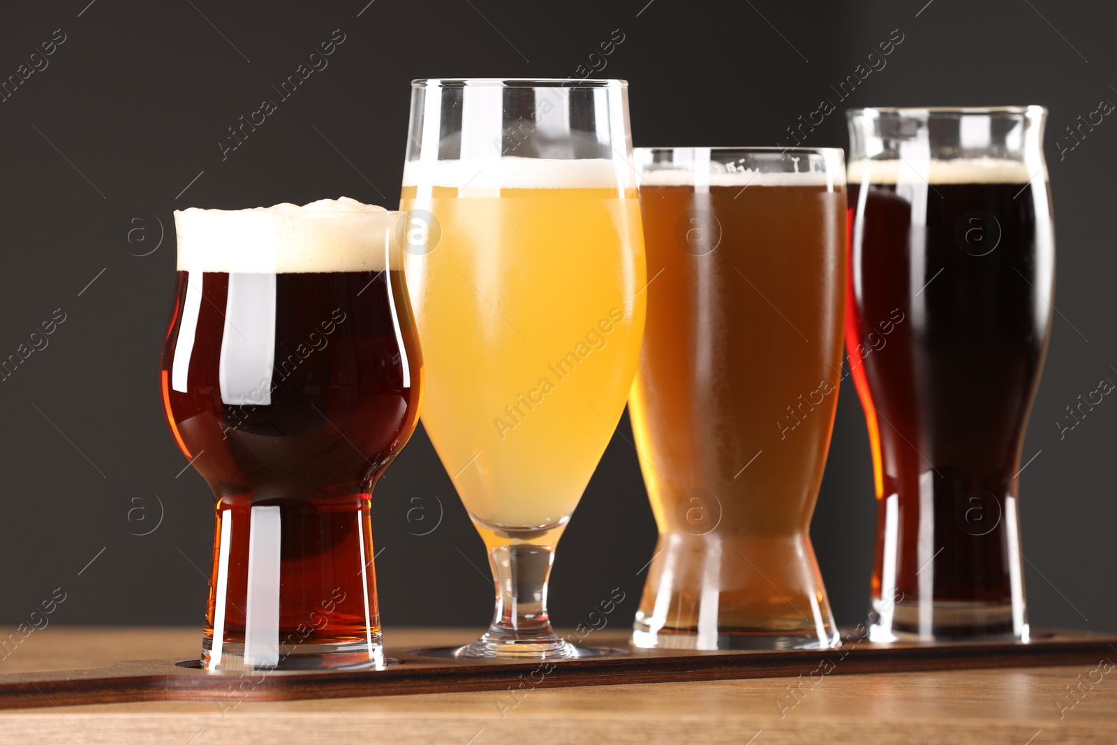 Photo of Glasses with different types of beer on wooden table indoors, closeup