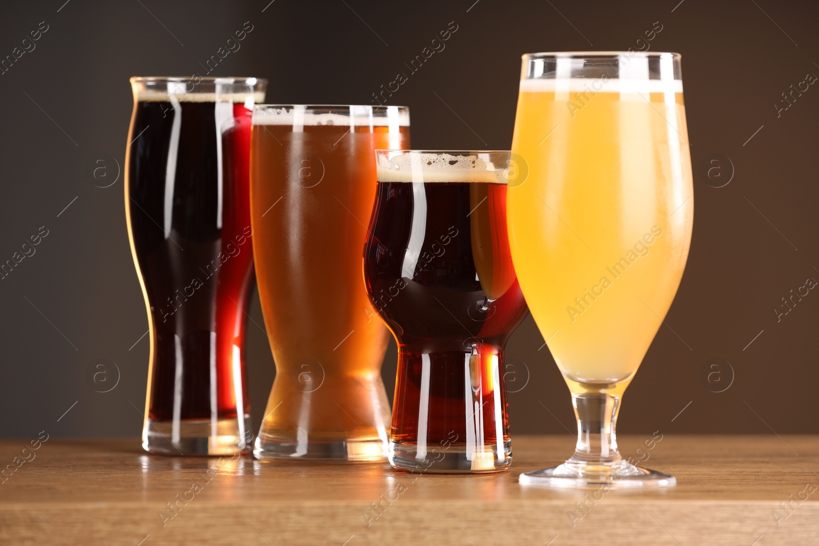 Photo of Glasses with different types of beer on wooden table indoors, closeup