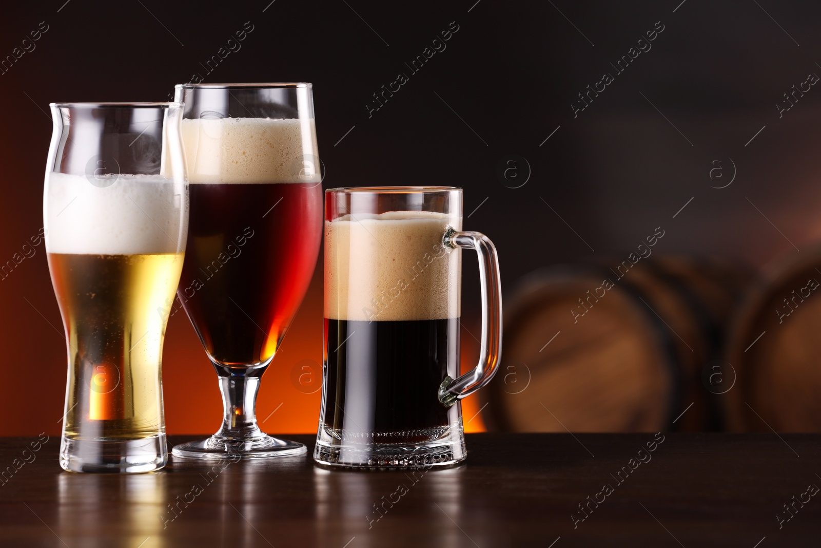 Photo of Glasses with different types of beer on wooden table in bar. Space for text