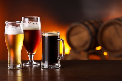 Photo of Glasses with different types of beer on wooden table in bar. Space for text