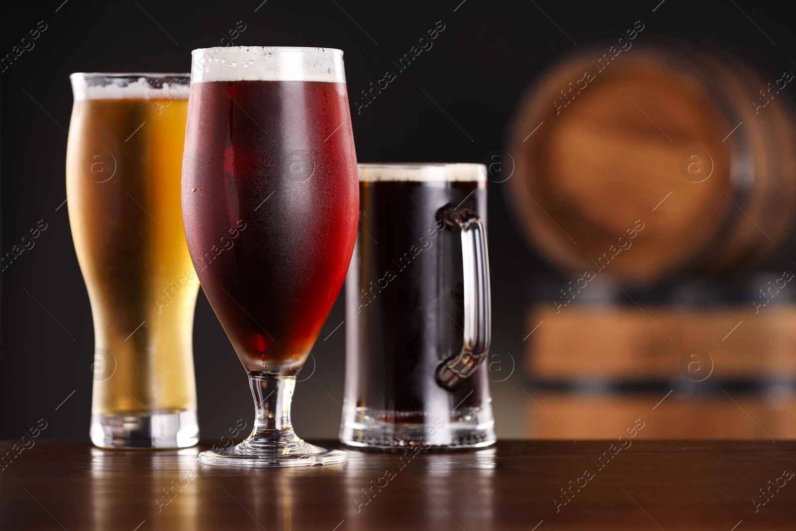 Photo of Glasses with different types of beer on wooden table in bar. Space for text