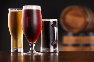 Photo of Glasses with different types of beer on wooden table in bar. Space for text