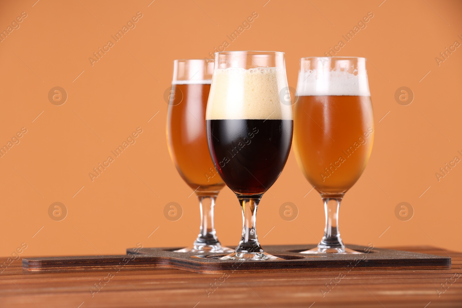 Photo of Glasses with different types of beer on wooden table