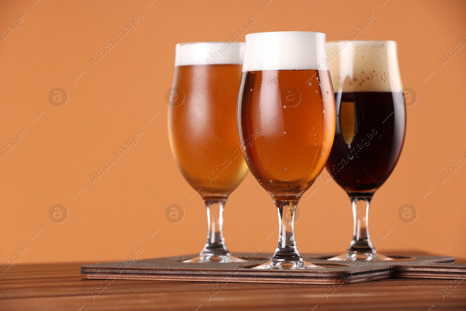 Photo of Glasses with different types of beer on wooden table