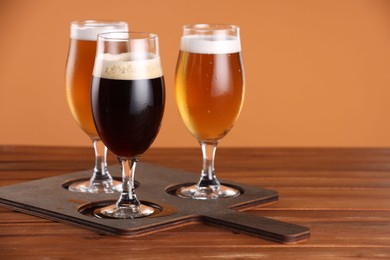 Photo of Glasses with different types of beer on wooden table