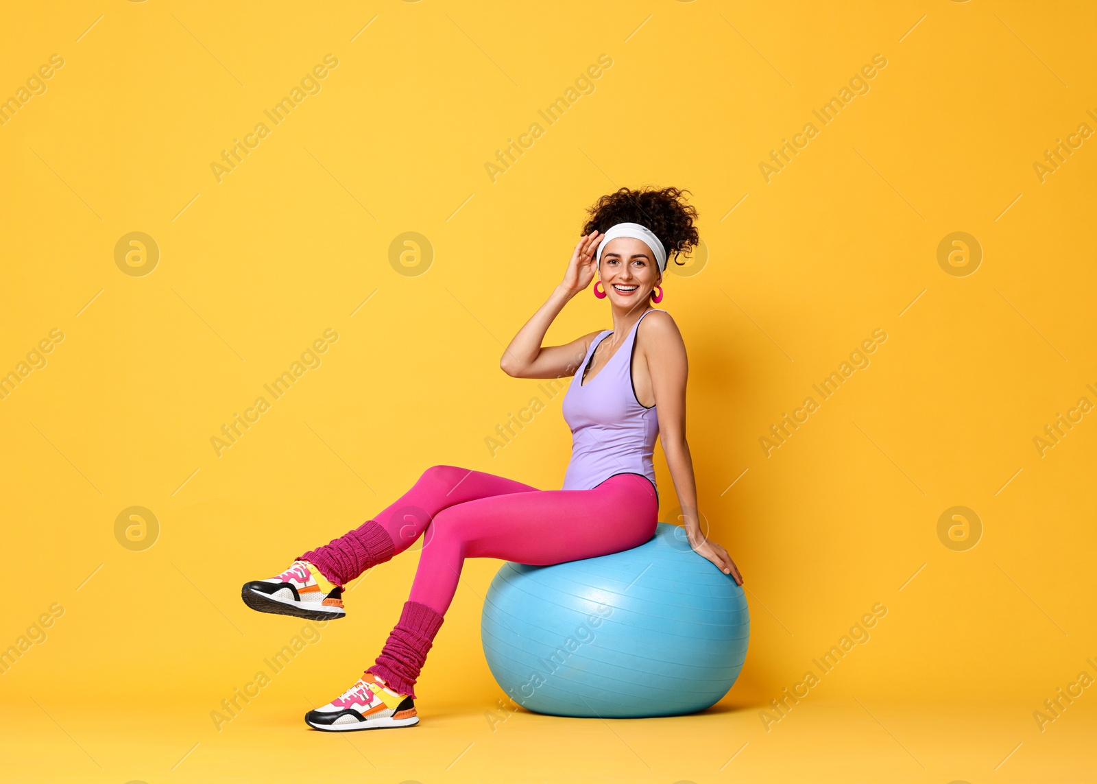 Photo of Aerobics. Woman with fitness ball on orange background