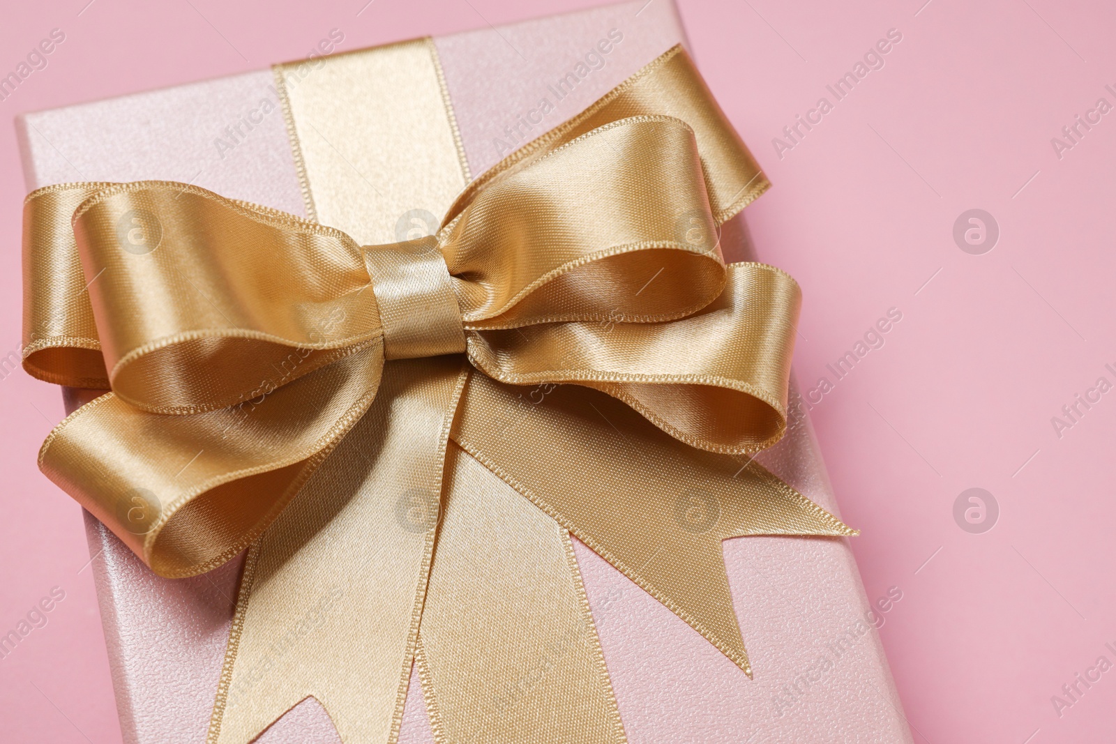 Photo of Gift box with bow on dusty pink background, closeup