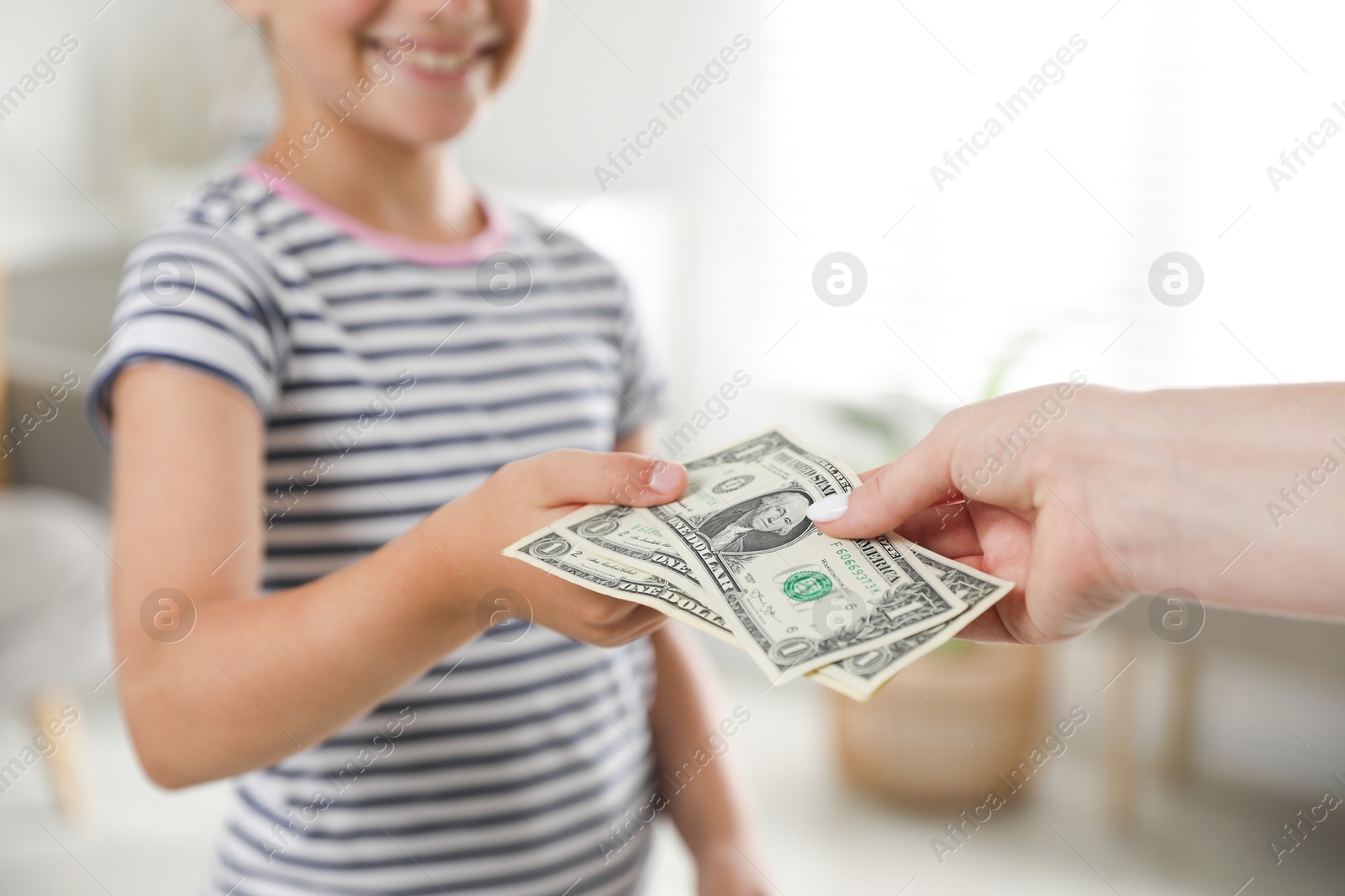 Photo of Mother giving pocket money to her daughter at home, closeup