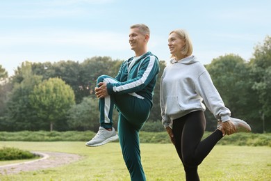 Photo of Happy couple doing exercises in park. Healthy lifestyle