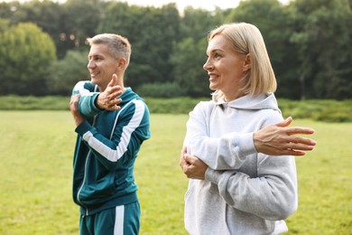 Happy couple doing exercises in park, selective focus