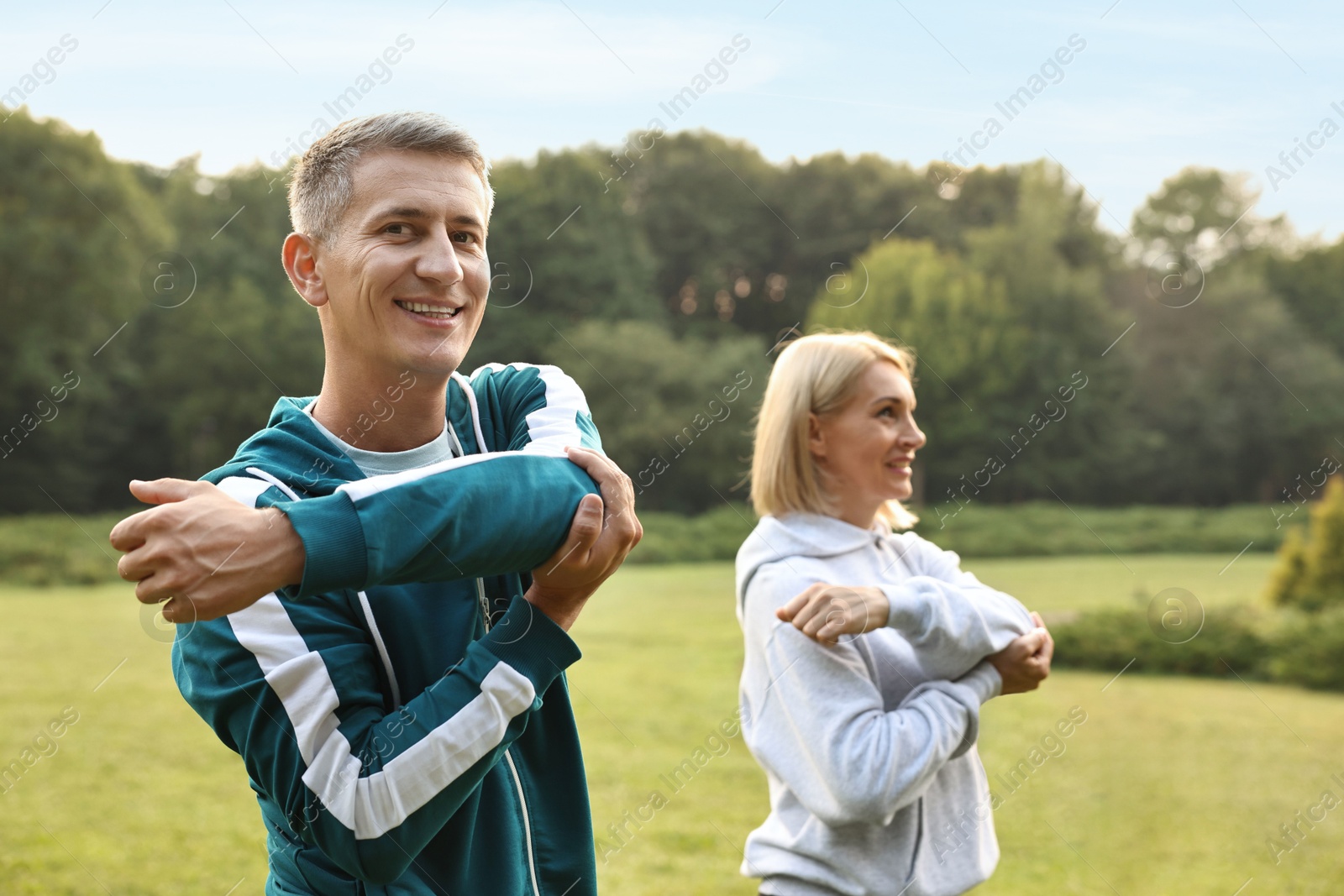 Photo of Happy couple doing exercises in park, selective focus