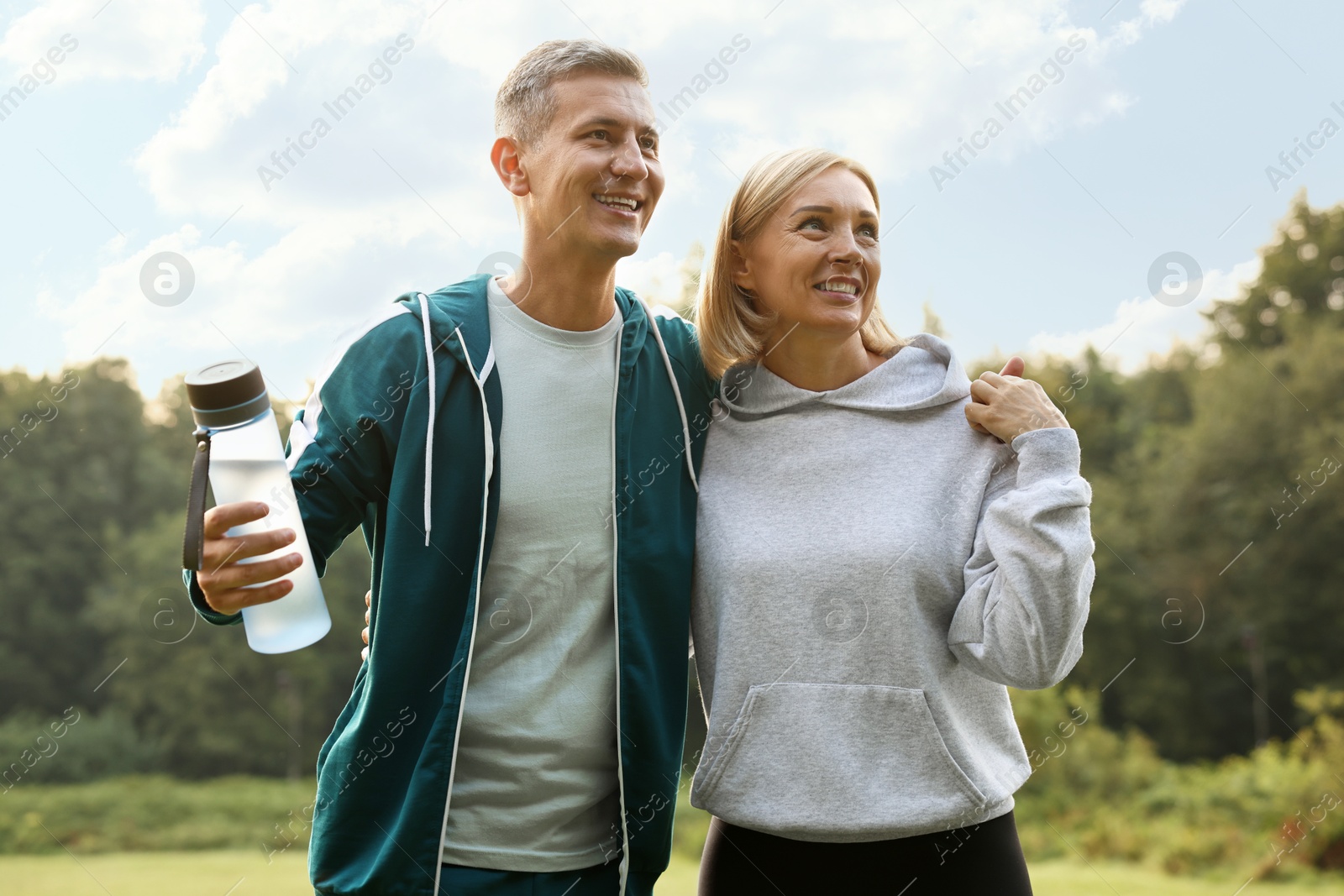 Photo of Happy couple with bottle of water in park