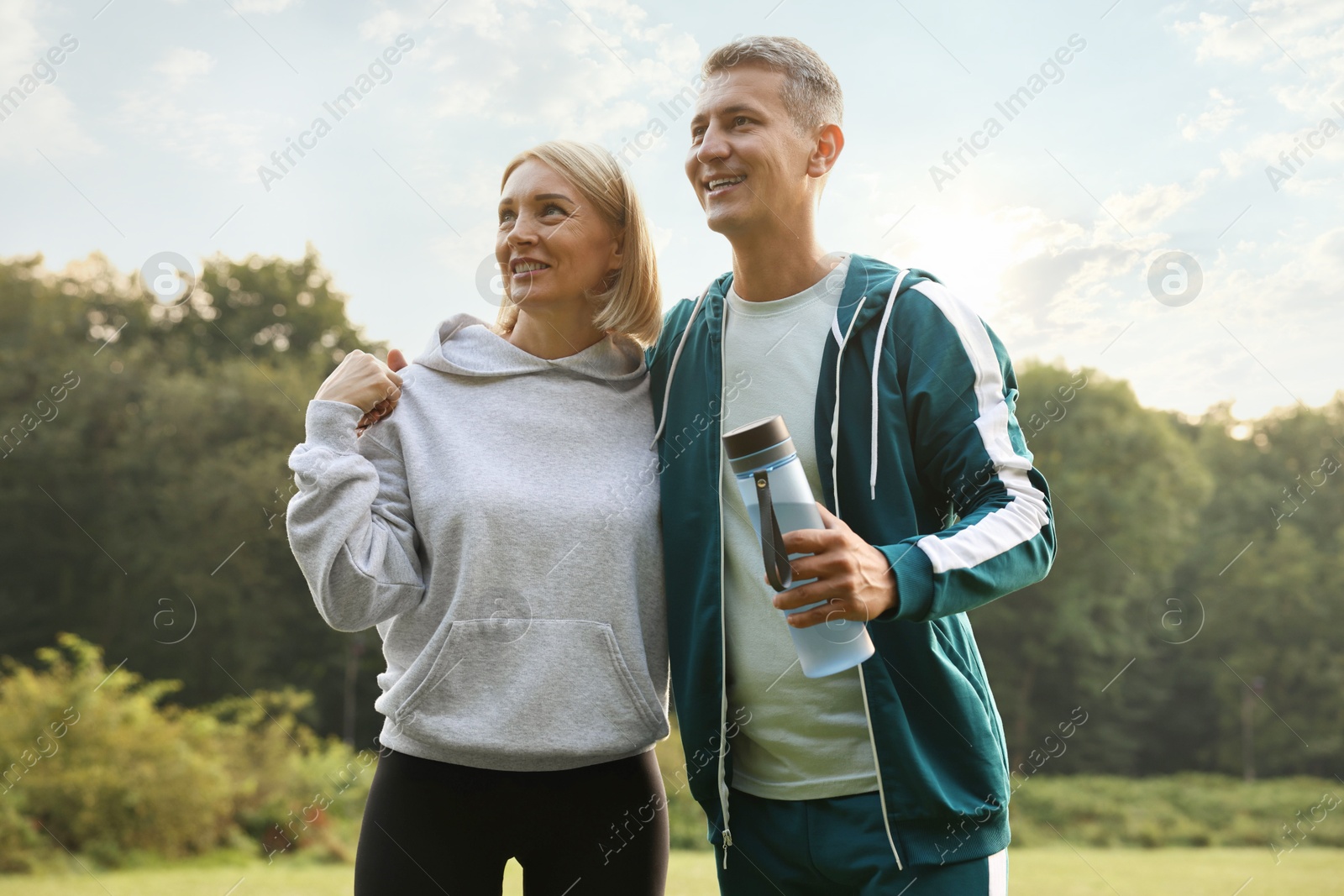 Photo of Happy couple with bottle of water in park