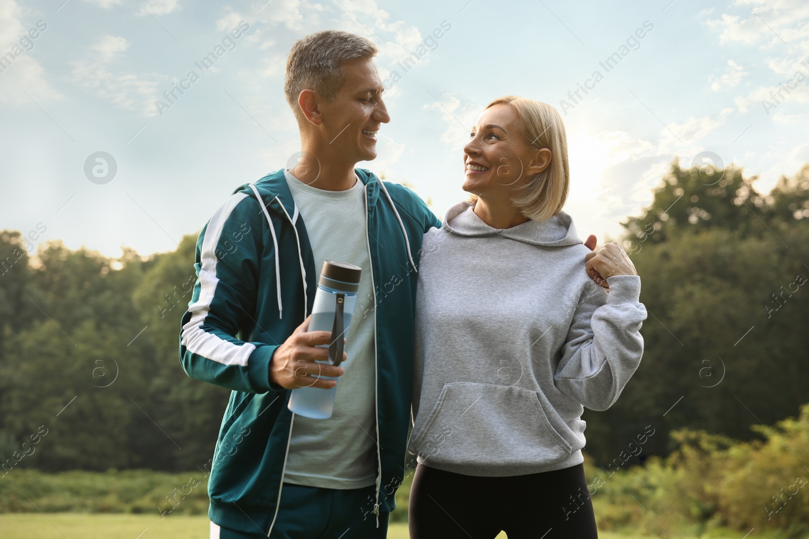 Photo of Happy couple with bottle of water in park