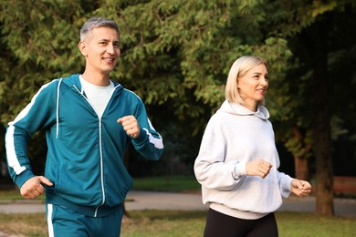 Happy couple in sportswear running outdoors. Healthy lifestyle