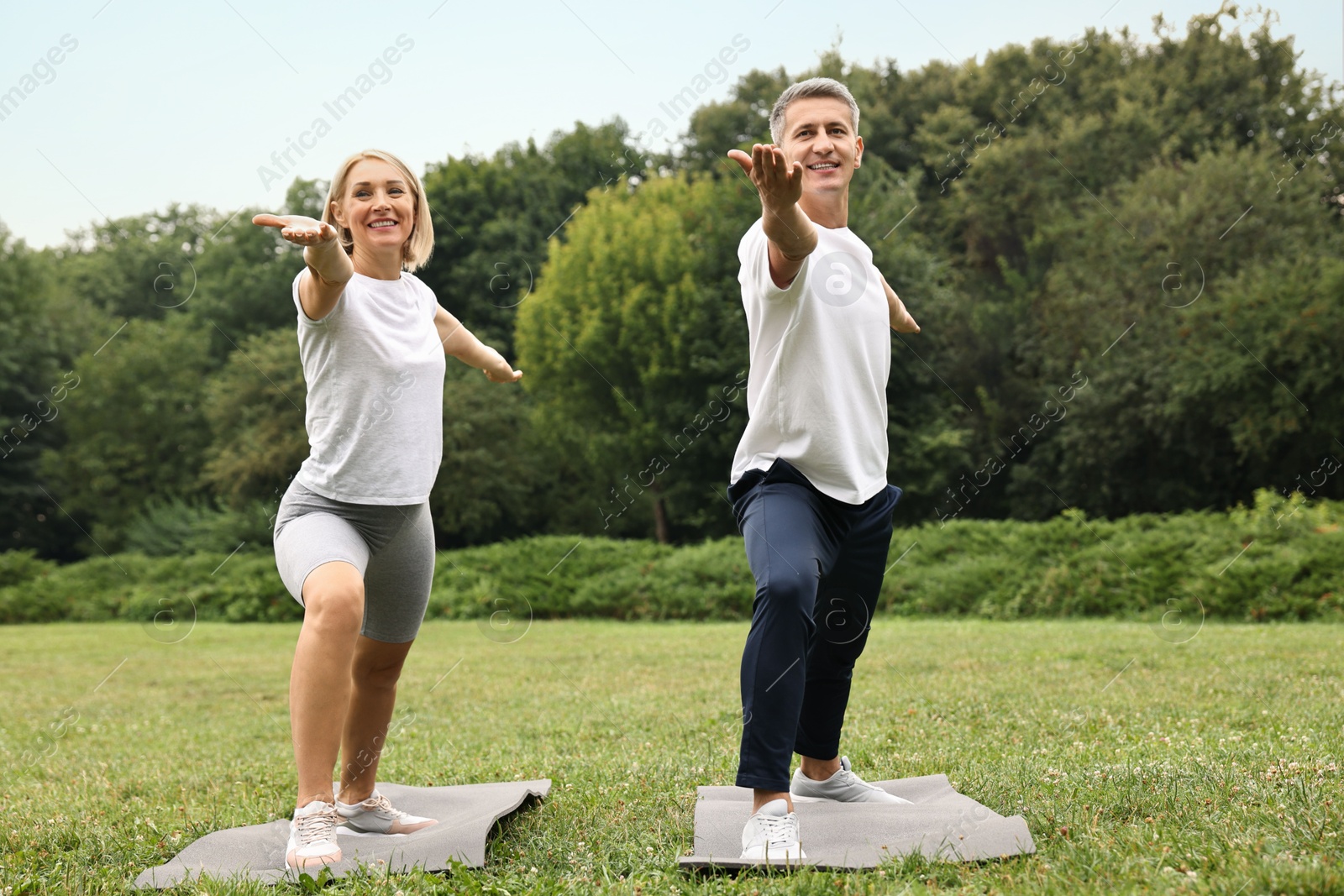 Photo of Happy couple doing exercises in park. Healthy lifestyle