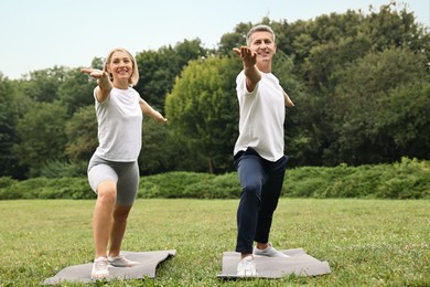 Photo of Happy couple doing exercises in park. Healthy lifestyle