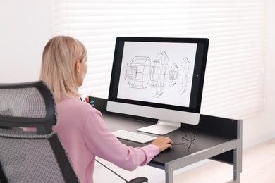 Architect making digital engineering drawing on computer at table in office