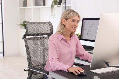 Architect making digital engineering drawing on computer at table in office