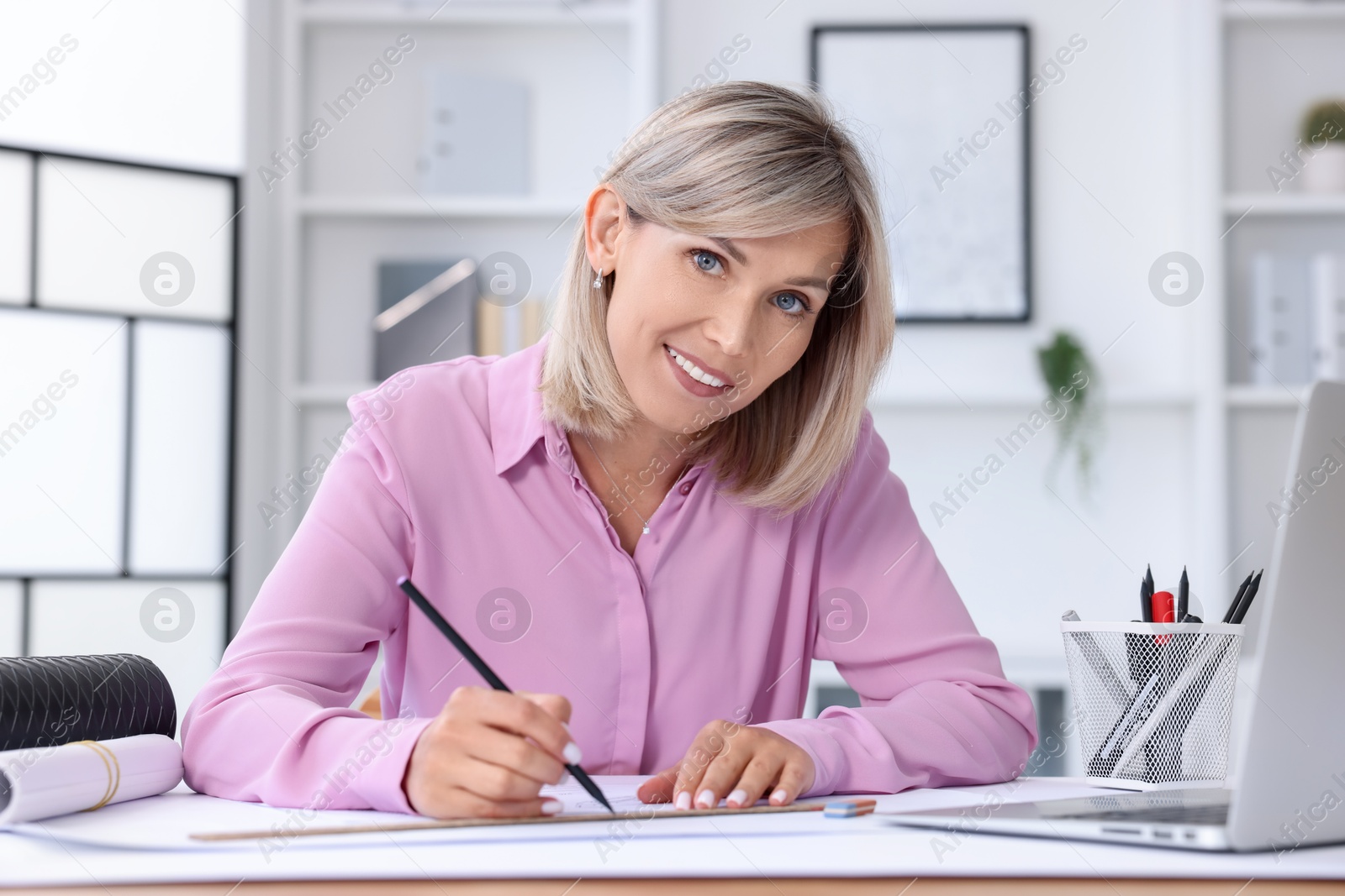 Photo of Architect making engineering drawing at table in office