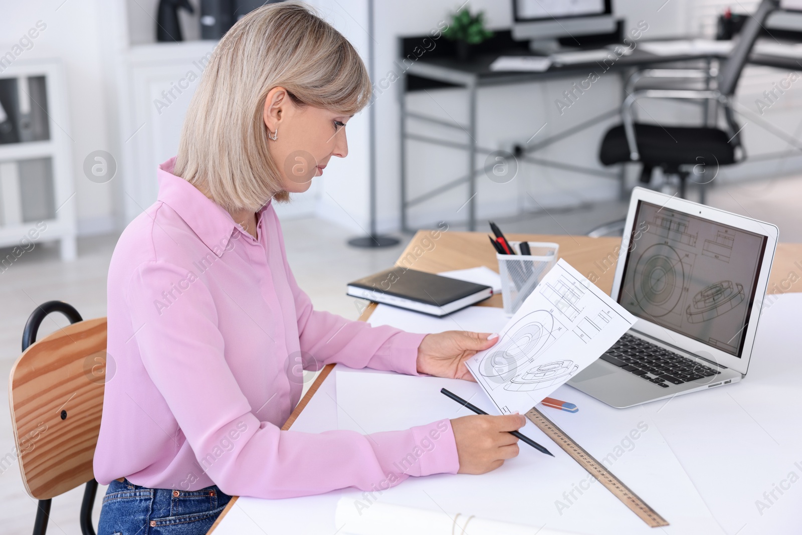 Photo of Architect making engineering drawing at table in office