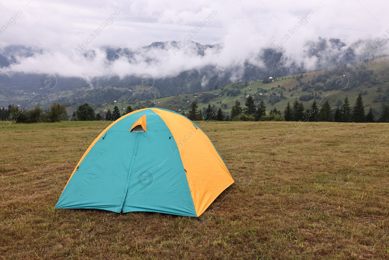 Photo of Camping tent on grass in mountains, space for text