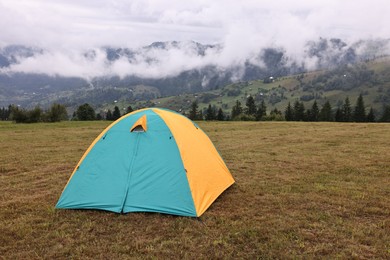 Photo of Camping tent on grass in mountains, space for text