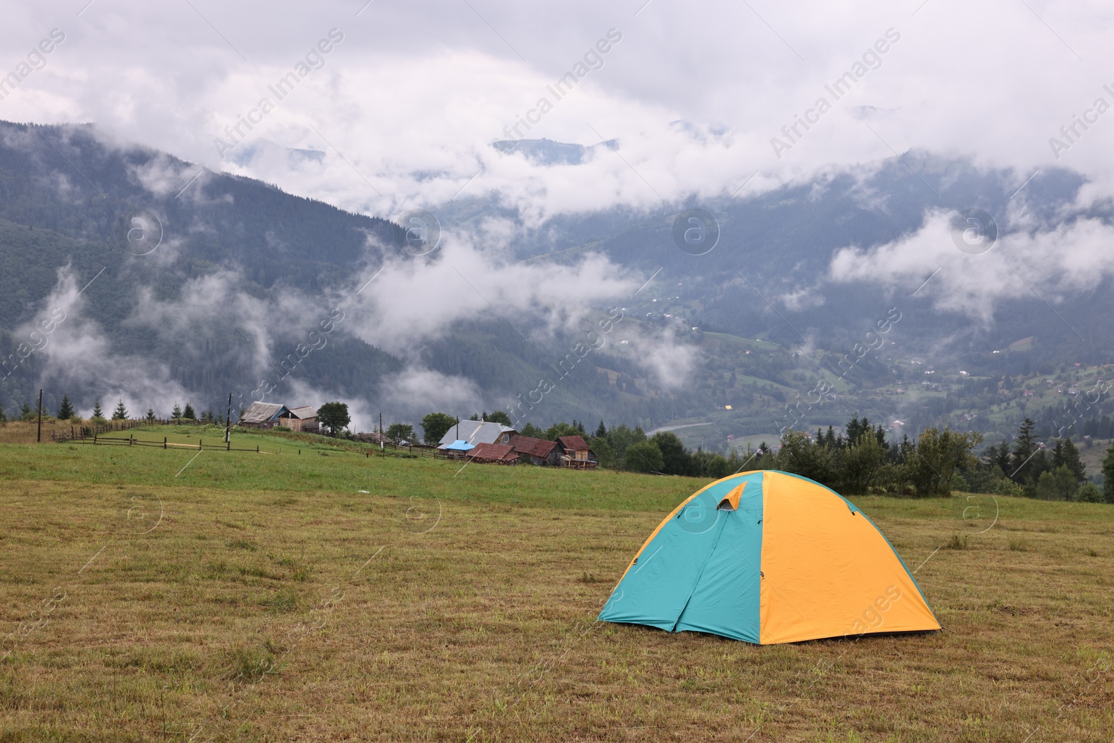 Photo of Camping tent on grass in mountains, space for text