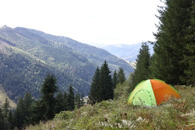 Photo of Camping tent on green grass in mountains