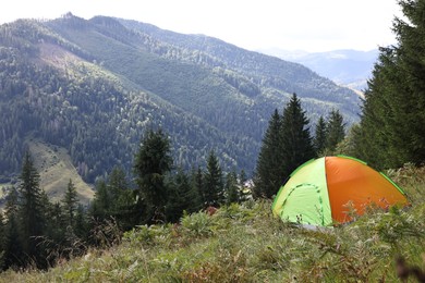 Photo of Camping tent on green grass in mountains