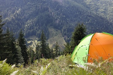 Camping tent on green grass in mountains