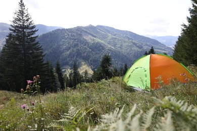 Camping tent on green grass in mountains