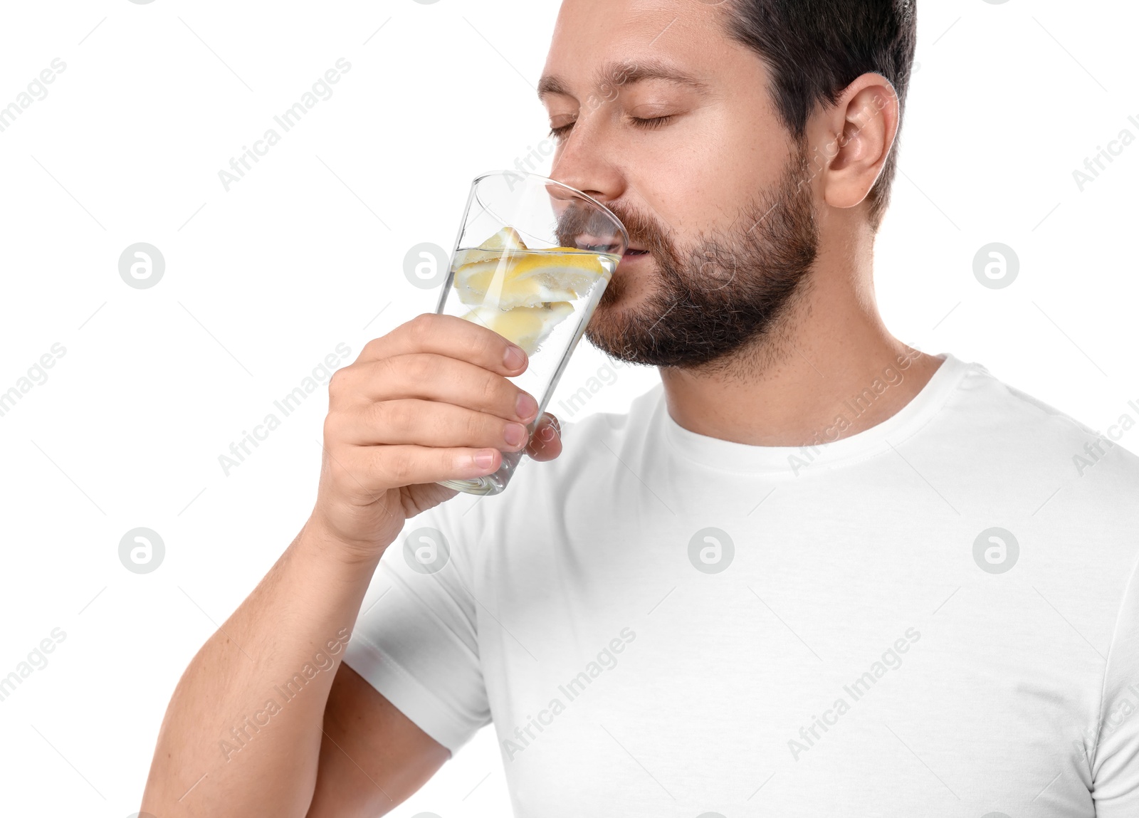 Photo of Handsome man drinking water with lemon on white background