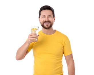 Happy man holding glass of water with lemon on white background