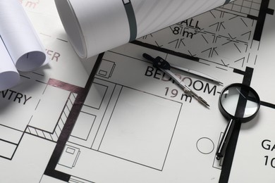 Dividers and magnifying glass on different engineering drawings