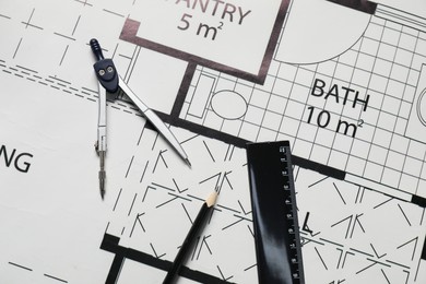 Photo of Ruler, dividers and pencil on different engineering drawings, top view