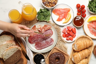 Photo of Woman having brunch at white table, top view