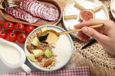 Photo of Woman having brunch at white table, top view